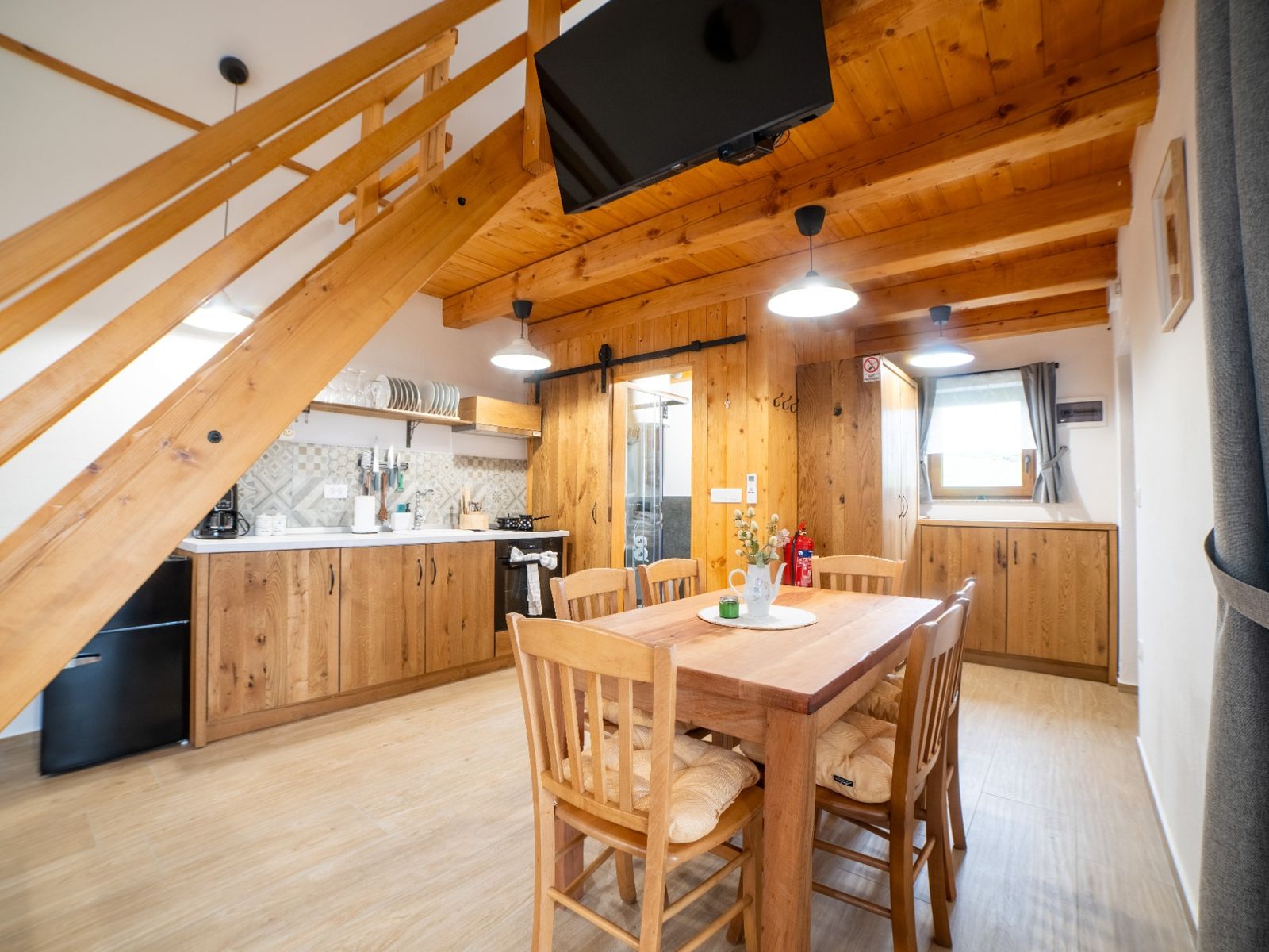 Notranjost glamping hiške v Rogatcu z leseno opremo in kuhinjo